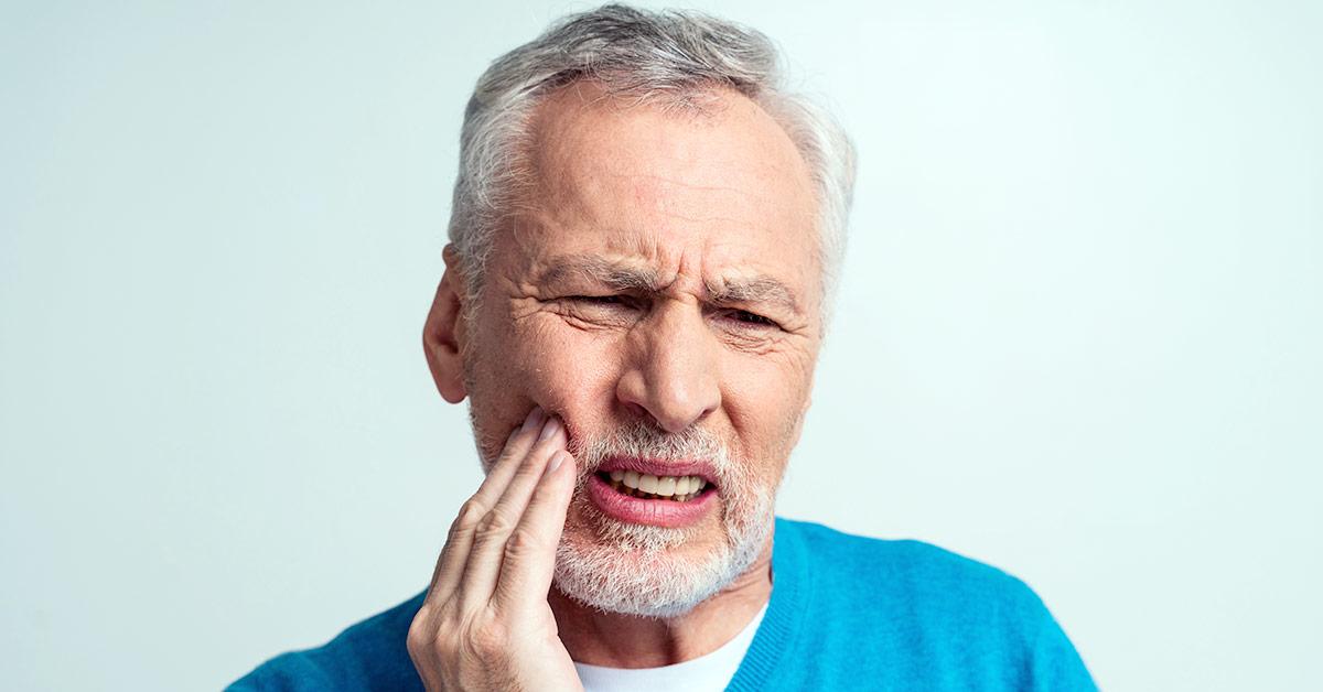 Hombre de mediana edad sufre dolor en la boca a causa de un flemón